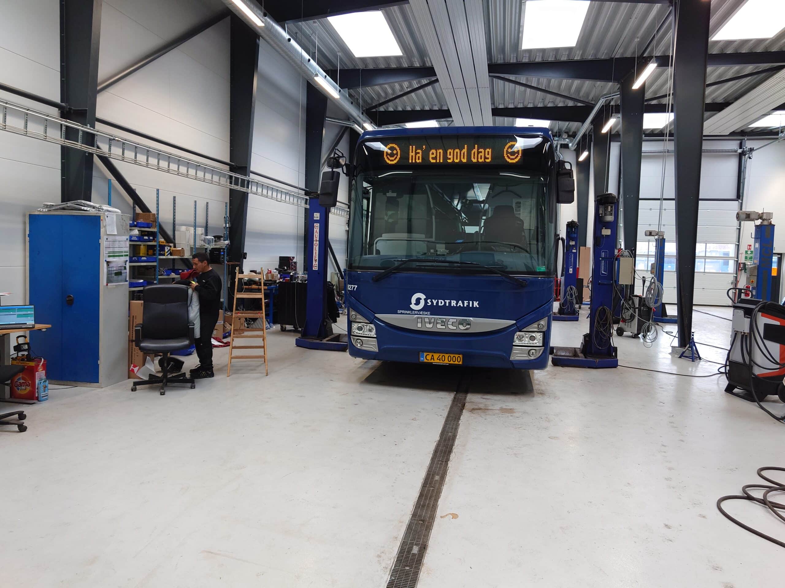 blå bus i en parkeringshal med teksten ha en god dag på displayet